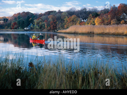 Padre e figlio canoa su una tranquilla e serena New England fiume in autunno Foto Stock