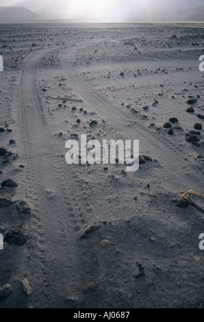 Tracce di pneumatici e rocce laviche sul vasto Ash Plain vicino a Mount Yasur, e vulcano attivo sull'isola di Tanna, Vanuatu. Foto Stock