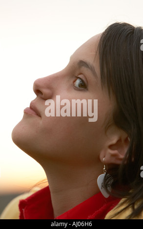 Ragazza giovane guardando dal lato sorridente con orecchino ribelle Foto Stock