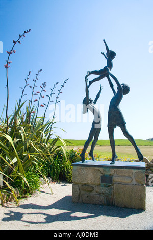 Tresco Abbey sub giardini tropicali con la scultura in bronzo di bambini che giocano in estate sole Tresco Isole Scilly Cornovaglia Foto Stock