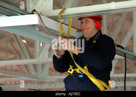 Elettricista lavora da una salute Cherrypicker norme di sicurezza Foto Stock