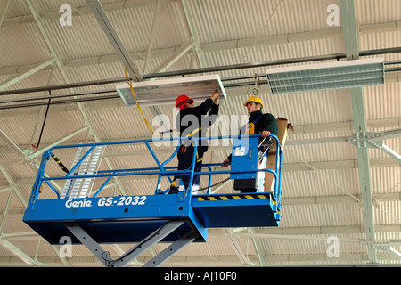 Elettricista lavora da una salute Cherrypicker norme di sicurezza Foto Stock