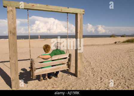 Giovane (45-55) altalene sulla spiaggia a Tybee Island Georgia USA, Fuga Romantica Foto Stock