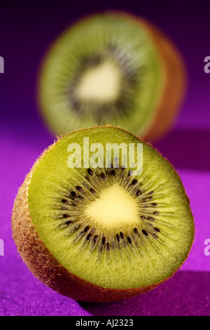 Due metà di un kiwi su uno sfondo viola Foto Stock