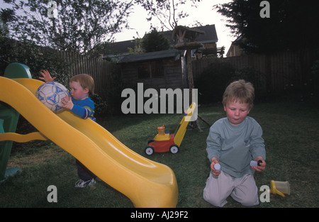 Due giovani fratelli giocare in giardino Bedfordshire Regno Unito Foto Stock