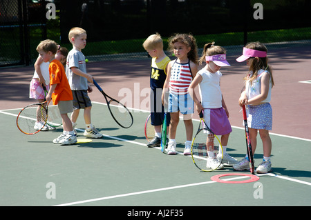 I ragazzi imparano a giocare a tennis presso il pubblico corte di ricreazione Foto Stock