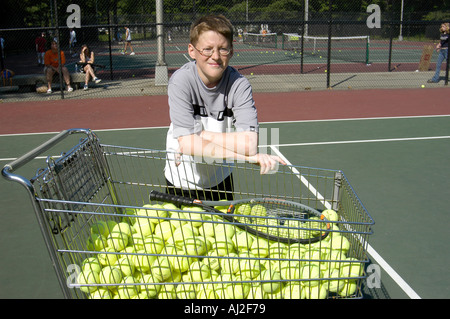 I ragazzi imparano a giocare a tennis presso il pubblico corte di ricreazione Foto Stock