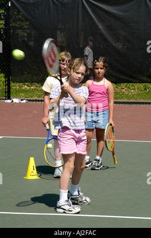 I ragazzi imparano a giocare a tennis presso il pubblico corte di ricreazione Foto Stock