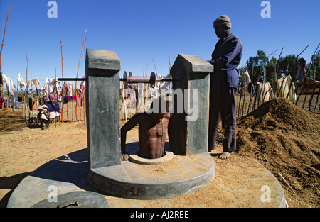 Abbassare un uomo per approfondire una famiglia bene durante le condizioni di siccità quando la tavola di acqua è caduto. Zimbabwe Foto Stock