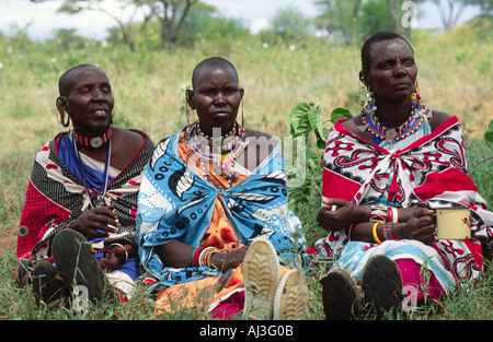 Un ritratto di tre donne maasai in abito tradizionale, bevendo tè durante una riunione del gruppo cooperativo femminile. Kajiado, Kenya Foto Stock