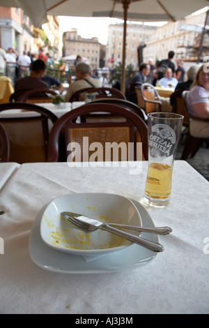 Completamente mangiati ciotola di spaghetti alla carbonara e mezzo bicchiere di birra seduti su un tavolo in un street cafe in Piazza Navona Foto Stock