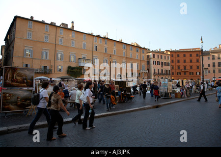 Turisti e aperto il mercato dell'arte nella sera in Piazza Navona Roma Lazio Italia Foto Stock