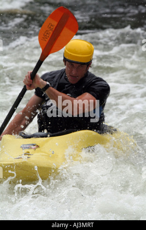 L'uomo paddling attraverso whitewater rapida Foto Stock