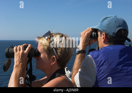 Primo piano di un uomo e di una donna a guardare il mare con il binocolo Foto Stock