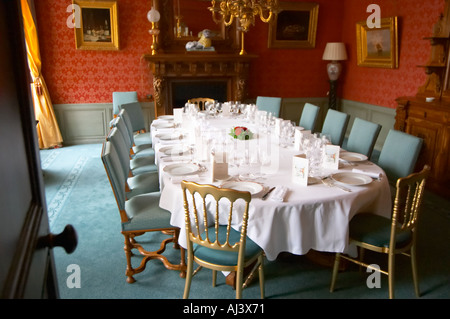 Il classico lussuosa sala da pranzo in stile antico impostato per una cena di gala con starched tovaglioli e tavolo bianco panno e molti bicchieri per la degustazione di champagne come visto attraverso la porta di ingresso a Champagne Deutz in Ay, Vallée de la Marne, Champagne, Marne, Ardenne, Francia, bassa luce grano sgranate Foto Stock