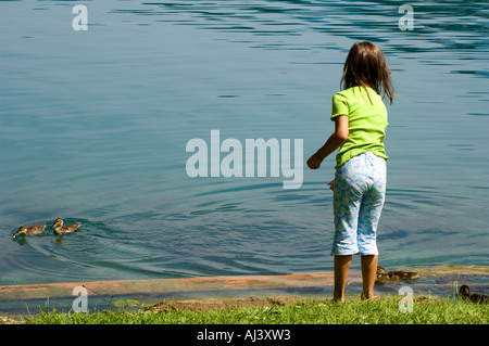 Una bambina alimenta le anatre sul lago di Bled Slovenia Foto Stock