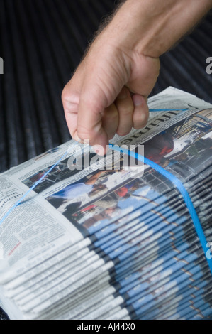 Supporto quotidiano il sollevamento di un fascio di quotidiani Foto Stock