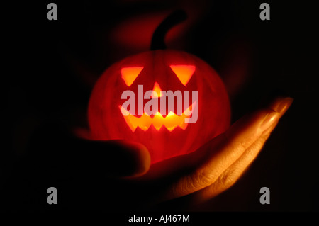 Mano con jack-o-lantern illuminato dall'interno Foto Stock