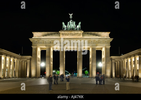 Una vista di turisti scattare fotografie al Brandenburger Tor o Porta di Brandeburgo di notte. Foto Stock