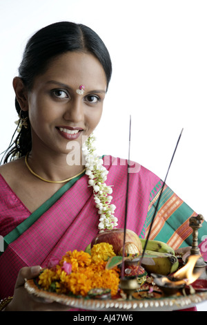 Ritratto di un sud donna indiana tenendo una piastra e sorridente Foto Stock