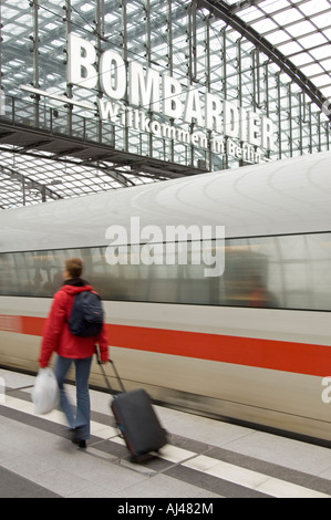 Un passeggero con la valigia camminare a piedi come una offuscata inter city express treno tira in Berlino stazione centrale. Foto Stock