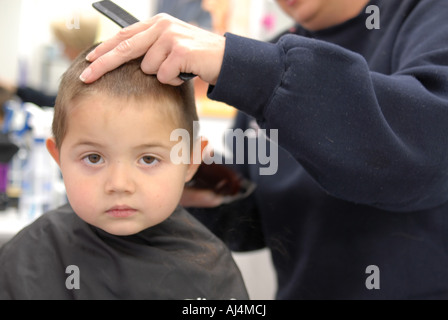 Ragazzo di ottenere un taglio di capelli in un negozio di barbiere Foto Stock
