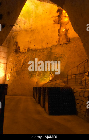 Nella cantina sotterranea che è una vecchia cava di gesso: migliaia e milioni di bottiglie di invecchiamento, questi sono in piedi in rack (pupitres) in attesa di sboccatura, Champagne Ruinart, Reims, Champagne, Marne, Ardenne, Francia, bassa luce grano sgranate Foto Stock