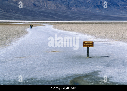 Brutto segno d'acqua accanto a un lago con le montagne in distanza Death Valley California USA Foto Stock