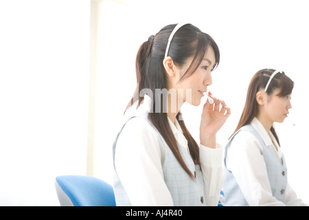 Due giovani donna che indossa le cuffie Foto Stock