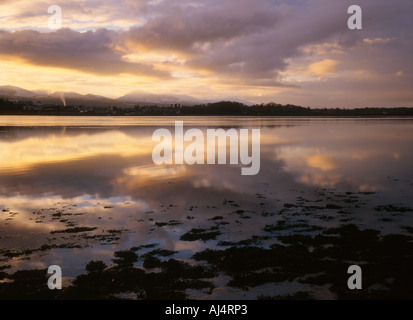 Sole sorge su Caernarfon e Snowdon, visto attraverso il Menai rettilinei da Anglesey Foto Stock