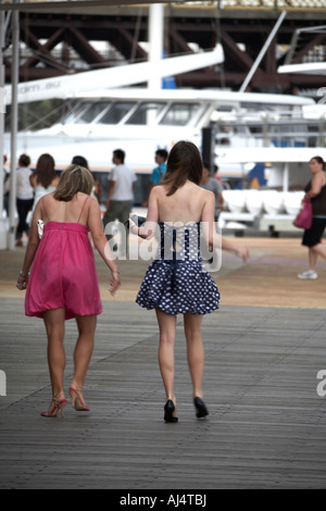 Traino di ragazze o giovani donne lo sminuzzamento lungo con tacchi alti su schede dopo Xmas Party in Darling Harbour Sydney New South Wales NSW Foto Stock