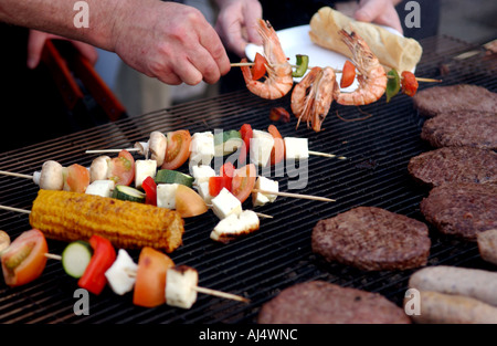 Il cibo viene preparato su uno spiedino con verdure e gamberi e cucinato su un barbecue estivo Foto Stock