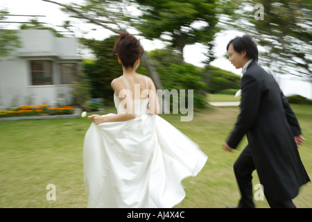 Sposa e lo sposo in esecuzione sul prato movimento sfocato Foto Stock