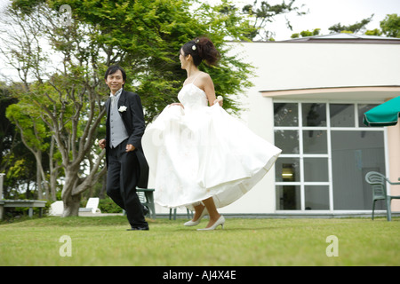 Sposa e lo sposo in esecuzione sul prato Foto Stock