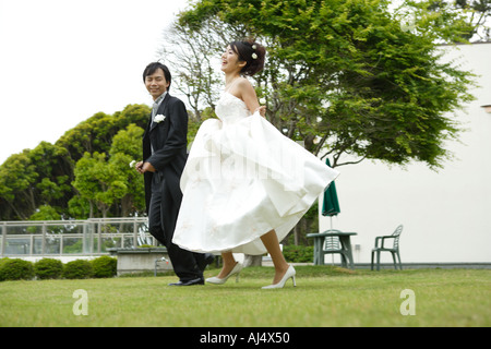 Sposa e lo sposo in esecuzione sul prato Foto Stock