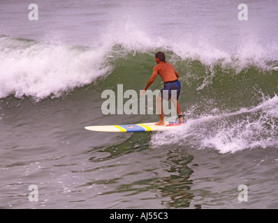 Unico longboard surfer godendo di una corsa su una piccola onda di rottura a North Beach Durban Natal provincia Sud Africa Foto Stock