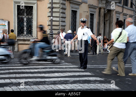 Velocità del traffico passato romano come poliziotto municipale dirige i pedoni attraverso la strada di attraversamento pedonale Via Teatro Marcello Foto Stock