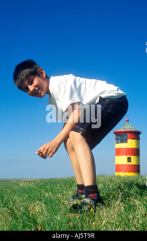 Falsa la foto di un giovane ragazzo cerca di sedersi su un faro Foto Stock