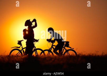 L'uomo prendendo un drink da una bottiglia di acqua donna su mountain bike bicicletta Hambledon sulla collina sopra la Blackmore Vale Dorset Inghilterra Foto Stock