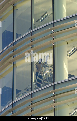Detergente per vetri al lavoro nel nuovo ufficio vuoto blocco Foto Stock
