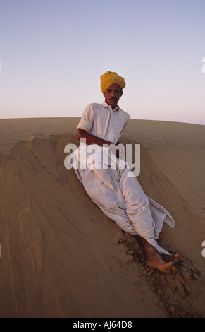 Giovani driver del cammello avente un periodo di riposo in una duna di sabbia nel deserto di Rajasthani fuori Jaisalmer Foto Stock