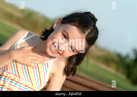 Una ragazza giovane e carina ride in un modo sfacciato Foto Stock