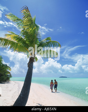 Giovane camminando sulla riva sabbiosa con Palm tree su un piede isola nei pressi di Aitutaki nelle Isole Cook Foto Stock