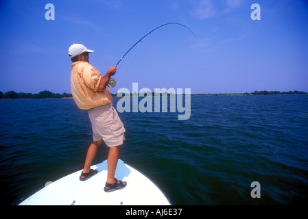 Uomo di Pesca a Mosca Report di Pesca fuori della barca prua a Savannah in Georgia USA Modello e Proprietà immagine rilasciata Foto Stock