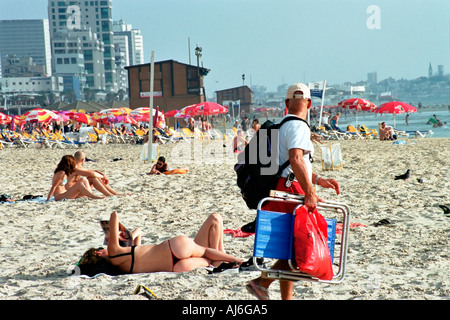 Israele Tel Aviv uomo fissando una donna per i bagni di sole con un laccetto Foto Stock