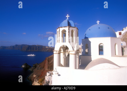 Chiesa greco-ortodossa e la nave su orizzonte vicino alla cittadina di Oia o Ia sull isola di Santorini in Grecia Europa Foto Stock