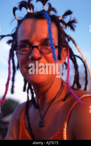 Festival goer avente capelli messi in dreadlocks al festival Womad Foto Stock