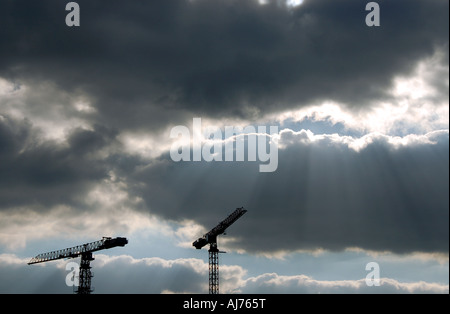 Gru edili contro un cielo drammatico Foto Stock