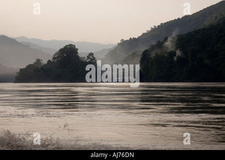 Vista di un villaggio/insediamento sulla riva del fiume dalla barca lenta tra Luang Prabang e Huay Xai sul fiume Mekong in Laos Foto Stock