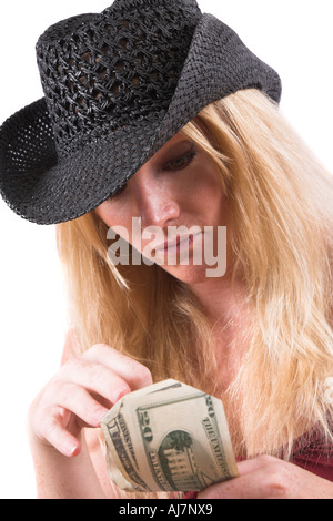 Bella donna bionda con nero cowboyhat conteggio dei dollari in mano Foto Stock